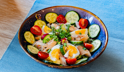 A plate of vegetable salad with trout and eggs