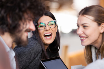 Young successful business people having a creative meeting at a cafe. Smiling and happy face expressions..