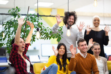 Team of successful multiethnic coworkers in modern office workplace. Waving. Diversity happines and success concept