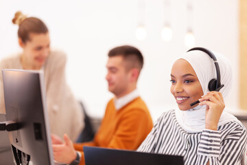 African american muslim girl with hijab and headset in a modern office. Customer service call center