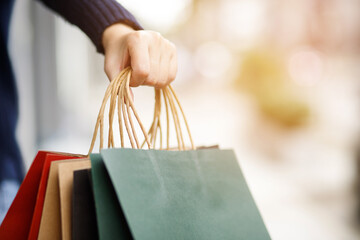 Close up of consumerism young woman holding hand many shopping bag in fashion boutique after buying...