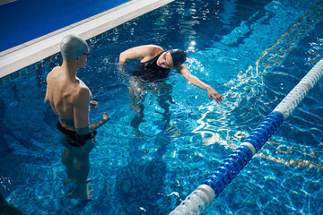 Coach telling young woman how to swim