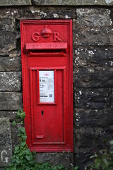 British postal service, red post box in the British countryside 