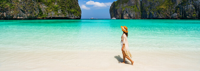 Young woman traveler relaxing and enjoying at beautiful tropical white sand beach at Maya bay in Krabi, Thailand, Summer vacation and Travel concept - obrazy, fototapety, plakaty