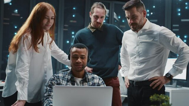 Diverse team of multi-ethnic IT specialists communicating in server room. African american administrator wearing headset for customer support service. Data center.