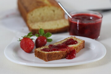 Sour cream pound cake along with a slice of pound cake with strawberry sauce spread.