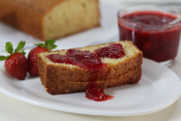 Sour cream pound cake along with a slice of pound cake with strawberry sauce spread.