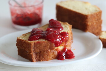 Sour cream pound cake along with a slice of pound cake with strawberry sauce spread.