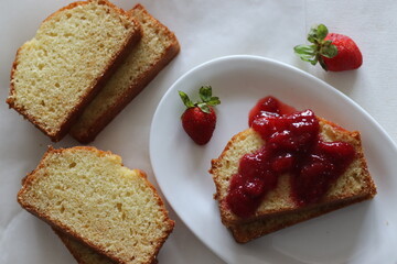 Sour cream pound cake along with a slice of pound cake with strawberry sauce spread.