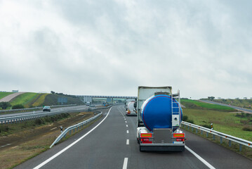 Fototapeta na wymiar Two tank trucks for the transport of food liquids circulating on the highway.