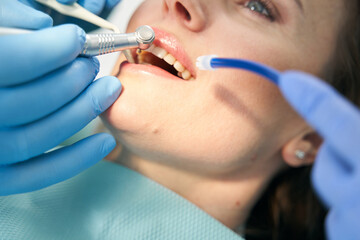 Dentist performing teeth treatment procedure with dental drill