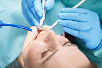 Dentist hands performing dental procedure with dental drill