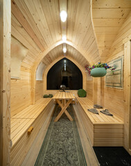 Wooden interior of modern bathhouse. Table and benches.