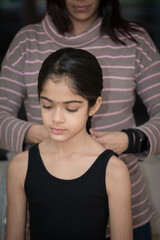 A British Indian girl having her hair and make-up done before modelling for a photoshoot. 