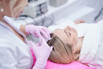 Obraz na płótnie Canvas Trichologist conducting mesotherapy hair treatment on client