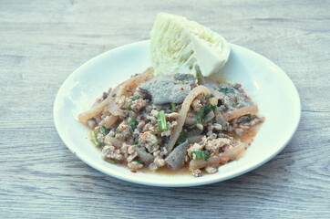 Thai spicy chop pork and slice liver with skin salad eat couple fresh cabbage on plate