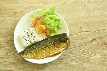 grilled saba fish or mackerel with rice topping sesame and salad on plate