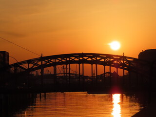 Fototapeta na wymiar sunset over a river in a city