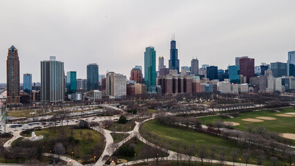 Fototapeta premium Chicago, IL USA- march 13th 2022: aerial drone shot of downtown Chicago by the river during early spring summer. the beautiful skyscrapers look futuristic along the green lake water