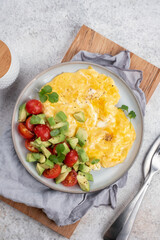 Scrambled eggs with cherry tomatoes and avocado