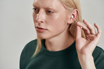 Partial image of guy cleaning ear with ear stick