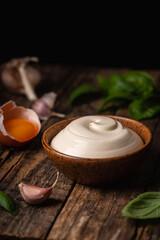 Fototapeta na wymiar Bowl of Homemade mayonnaise sauce with ingredients and herbs for cooking