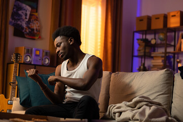 A young student is resting on a sofa in the living room, dances with hands, spends time alone, the...