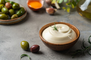 Bowl of Homemade mayonnaise sauce with olives, ingredients and herbs for cooking - obrazy, fototapety, plakaty