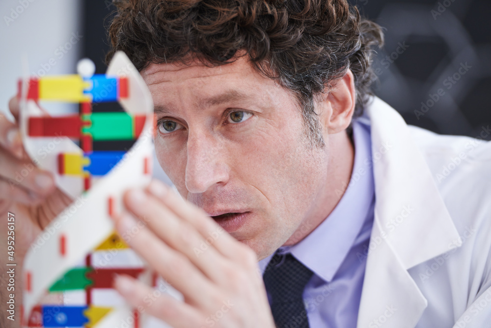 Poster fascinated by dna. a cropped shot of a scientist examining a dna model.