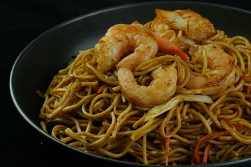 Spaghetti, pasta with tomato sauce and cherry tomatoes with basil on a dark background. Selective focus, copy space. shrimp spaghetti. 