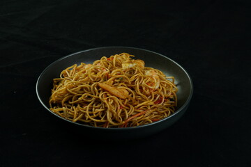 Spaghetti, pasta with tomato sauce and cherry tomatoes with basil on a dark background. Selective focus, copy space. shrimp spaghetti. 
