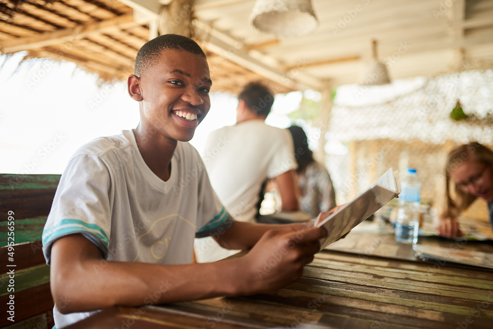Poster whats on the menu. portrait of a young man reading a menu in a restaurant.