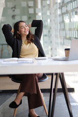 A business woman working in an office stretches to relax from work during breaks.