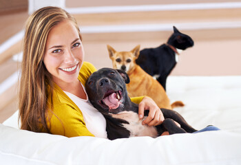 I guess Im an animal person. Portrait of an attractive young woman sitting with her pets on the...