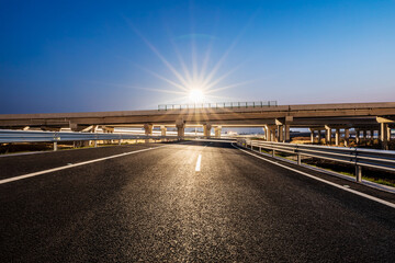 Asphalt highway and bridge with street lights at night