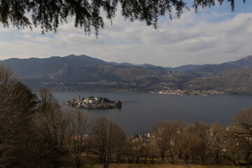 the Island of San Giulio and the city of Pella on the opposite side of Lake Orta seen from the ascent to the Sacro Monte