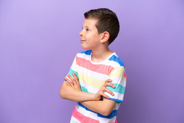 Little boy isolated on purple background looking to the side