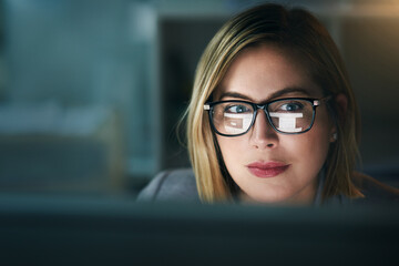 She stops at nothing. Shot of a young businesswoman working late on a computer in an office.