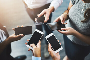 Share information with ease and efficiency. Closeup shot of a group of businesspeople using their cellphones in synchronicity.