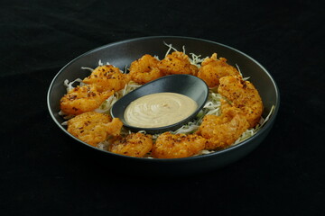 Fried squid or calamari rings with sauce.Fast food.  fried squids or octopus (calamari) with sauce - unhealthy foods