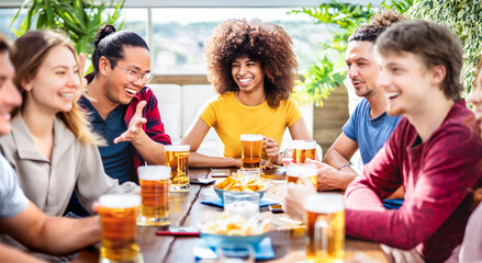 Young trendy people drinking beer at brewery bar lounge patio - Beverage life style concept with men and women having fun together on happy hour time - Bright vivid filter with focus on mid woman