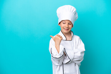 Little chef boy isolated on blue background pointing to the side to present a product