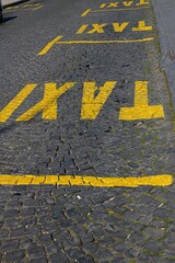 yellow signs on a road in Skopje marking parking spots for taxis
