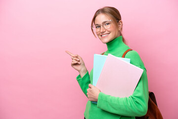 Young caucasian student woman isolated on pink background pointing finger to the side