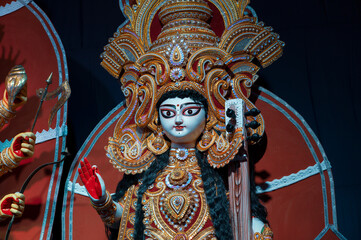 Obraz premium Goddess Saraswati idol , Durga Puja festival at night. Shot under colored light at Howrah, West Bengal, India. Biggest festival of Hinduism , celebrated all over the world.