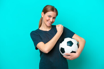 Young football player woman isolated on blue background celebrating a victory