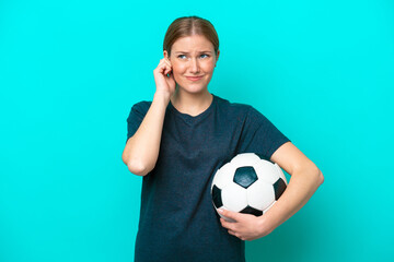 Young football player woman isolated on blue background frustrated and covering ears