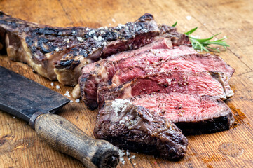 Traditional barbecue wagyu tomahawk beef steak sliced with spice and herbs served as close-up on a...