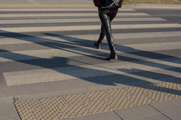 Women's legs on a crosswalk.
