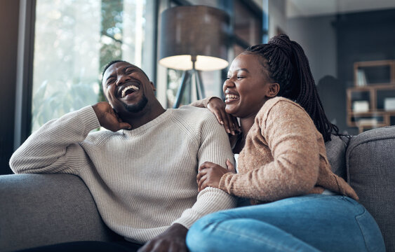 We never go a day without laughing. Cropped shot of a happy young couple sitting together and bonding during their weekend at home.